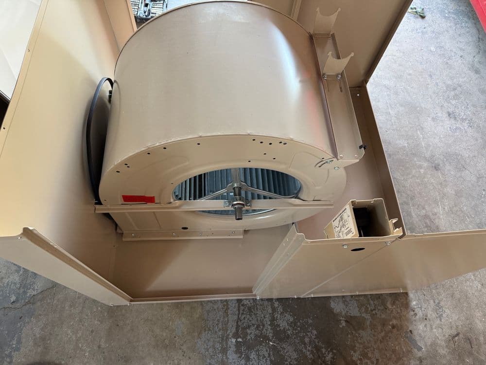 Industrial HVAC blower fan assembly in a metal housing, showing internal components.